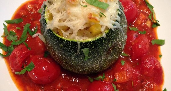 Vegetarisch gefüllte runde Zucchini auf Tomatenragout
